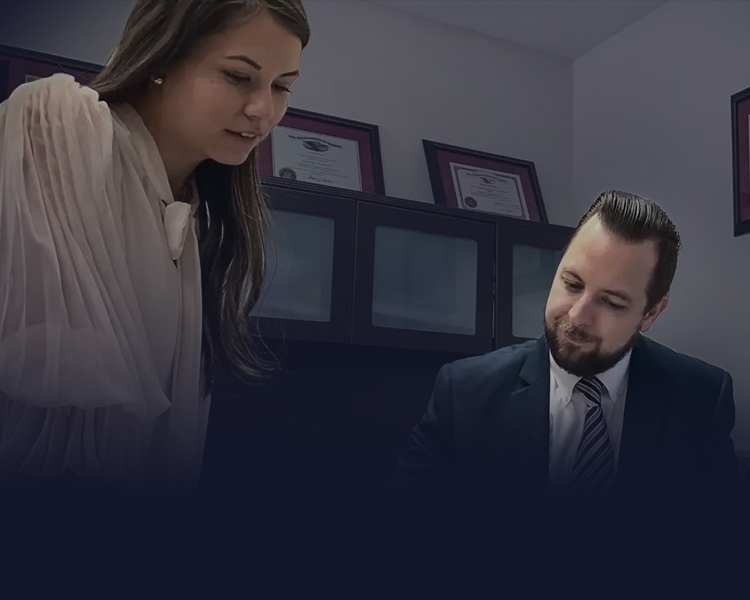 A woman and a man in a professional setting, discussing documents